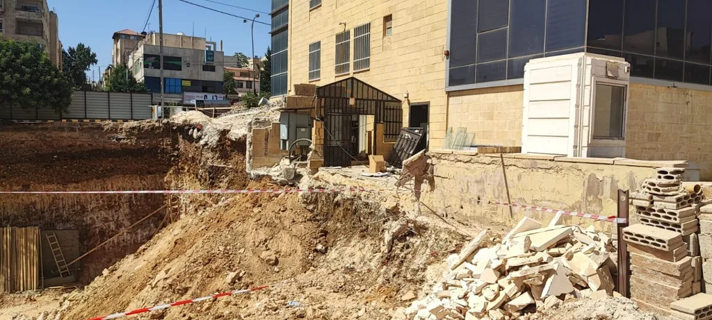 أعمال حفر تتسبب بانهيار جدار استنادي لأحد المجمعات التجارية بعمان